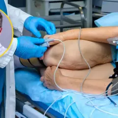 Lekarz w rękawiczkach przygotowuje pacjenta do zabiegu. Ile godzin trwa operacja jelita grubego? To zależy od wielu czynników.