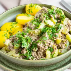 Schmorgurken mit Hack, Omas Rezept: Ein deftiger Eintopf mit Hackfleisch, Gurkenstücken und Salzkartoffeln, garniert mit Petersilie.