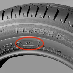Detalle de un neumático con los números 195/65 R 15 y el código 91H resaltados.
