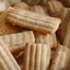 Stos ciastek ze skwarkami, pieczonych na papierze, z charakterystycznymi prążkami.