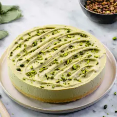 Delizioso cheesecake al pistacchio, guarnito con granella verde brillante. Un tripudio di gusto e colore.