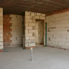 Budowa wnętrza z bloczków betonowych, widoczna ścianka działowa z gk w trakcie prac.