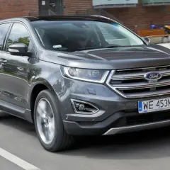 Szary Ford Edge 2.0 Ecoboost w ruchu miejskim.