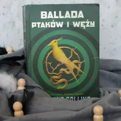 Okładka "Ballady ptaków i węży" z cyklu "Igrzyska Śmierci". Żółty ptak i wąż na tle zielonych kręgów.