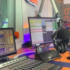 W studiu radiowym, gdzie słychać muzykę z **radio eska2 online**, wiszą słuchawki. Na monitorach widać zegar i program radiowy.