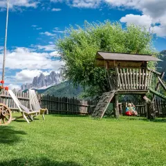 Giardino con altalena e montagne sullo sfondo, ideale per agriturismi con gallo rosso.