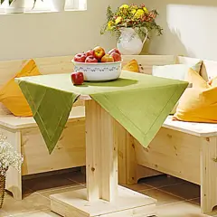 Holzige Eckbank mit Schlaffunktion selber bauen: Gemütliche Sitzecke mit Tisch, Äpfeln und Blumenkorb.