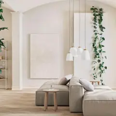Ein großes, rankendes Zimmerpflanzen-Ensemble umrahmt eine gemütliche Wohnzimmerecke mit einem beigen Sofa und Hängeleuchten.