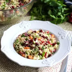 En härlig couscous sallad med bönor, rädisor och örter serveras på en vit tallrik.