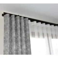 System wave zasłony: szara, wzorzysta zasłona obok transparentnej, białej. Eleganckie upięcie na czarnej szynie.