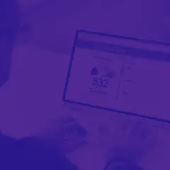 Osoba pisząca na laptopie, na ekranie którego widnieje raport oceny kredytowej z wynikiem 832.
