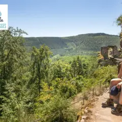 Une randonneuse profite de la vue sur les Vosges, près d'un ancien château. Le sentier gr 53 offre des paysages magnifiques.