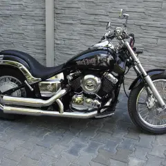 Czarny motocykl Yamaha Drag Star 650 z ozdobami czaszek. Pojemność baku pozwala na długie podróże.