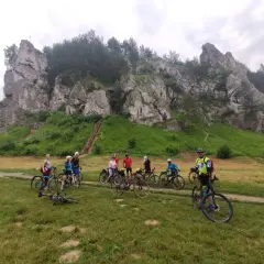 Grupa rowerzystów na tle skalnych ostańców. Jura Krakowsko-Częstochowska rowerem to wspaniała przygoda.