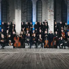 En stor orkester samlad framför Oscars kyrkan, redo att framföra storslagen musik.