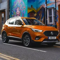 Pomarańczowy MG ZS na tle kolorowego muralu. Czy to marka MG? Tak, to MG!