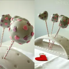 Süße Sally Cake Pops mit rosa und lila Herzen verziert, bereit für eine romantische Feier.