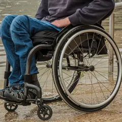 Osoba na wózku inwalidzkim, zmagająca się z rozszczepem kręgosłupa. Czy da się wyleczyć? Nadzieja i determinacja w codziennym życiu.