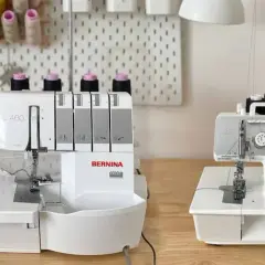 Two Bernina overlock machines, a serger vs overlock comparison, sit on a wooden table.
