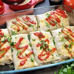 Zapiekana tortilla z mięsem mielonym, serem i ketchupem, posypana natką pietruszki, w szklanym naczyniu.