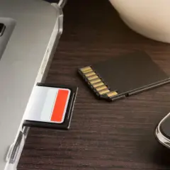 SD-Karte im Laptop-Slot, daneben eine weitere Karte und ein Smartphone. Die SD-Karte im Handy wird nicht erkannt.