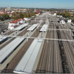 Widok z lotu ptaka na dworzec PKP Ełk z licznymi torami, peronami i budynkami. W oddali widać miasto.
