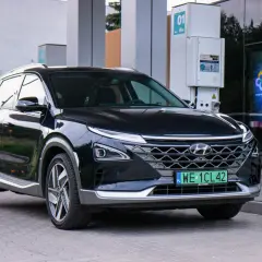 Czarny Hyundai na wodór zaparkowany przy stacji tankowania. Nowoczesny design i ekologiczne paliwo.