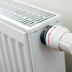 Biały grzejnik z termostatem. Gdy nie grzeje, sprawdź, jak naprawić grzejnik elektryczny, zaczynając od regulacji pokrętła.