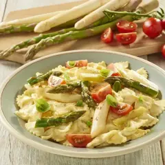 Pyszne szparagi na obiad w kremowym sosie z makaronem farfalle, pomidorkami i bazylią.