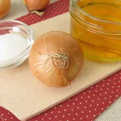 Składniki na domowy syrop z cebuli na kaszel: cebula, cukier i miód.