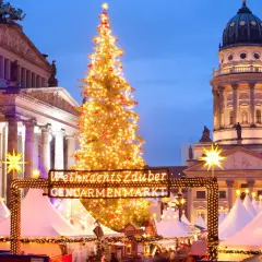 Jarmark Gendarmenmarkt w Berlinie, jeden z najpiękniejszych jarmarków bożonarodzeniowych w Europie, z choinką i kopułą kościoła w tle.