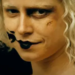 Blondynka z makijażem jak z nowych horrorów, czarne usta i blizna na policzku.