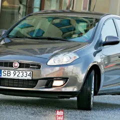 Szary Fiat Bravo 2 z tablicą rejestracyjną SB 92334 na tle budynku.