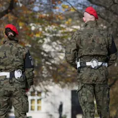 Dwóch żołnierzy w mundurach moro i czerwonych beretach stoi na tle drzew. Czy wojsko może zabrać samochód? To pytanie pozostaje bez odpowiedzi.