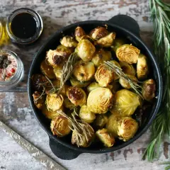 Cavoletti di Bruxelles arrostiti in padella con rosmarino, accompagnati da olio, aceto balsamico e sale aromatizzato.