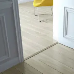 Une alternative barre de seuil discrète sépare deux pièces aux sols en parquet clair.