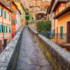 Un vicolo pittoresco a Perugia, con case colorate e un ponte in pietra. Perfetto per scoprire le cose da fare a Perugia.