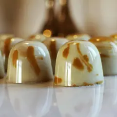 En rad blanka praliner med marmorerad ganache. Perfekt för ett ganache recept till praliner.