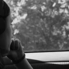 Ragazza con cuffie guarda fuori dal finestrino, persa nei suoi pensieri, come in un loop di depressione, ripetere sempre le stesse cose.