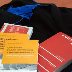 Książki prawnicze o postępowaniu karnym i sporządzaniu środków odwoławczych leżą obok tog. Czy rozprawa może się odbyć bez oskarżonego?
