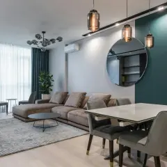 Nowoczesne rodzaje lamp sufitowych: wiszące nad stołem i wpuszczane w czarny pas.