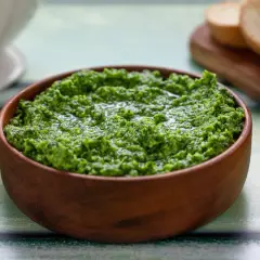 Pesto di rucola Bimby appena fatto, pronto per essere gustato con crostini di pane.