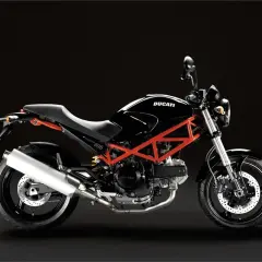 Ducati Monster 695 ficha técnica: una moto negra con chasis tubular rojo, asiento negro y escape plateado, lista para la carretera.