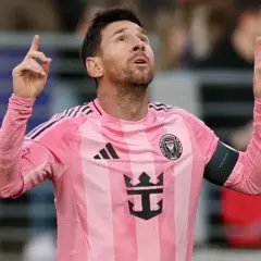 Piłkarz Lionel Messi w różowej koszulce Interu Miami, z uniesionymi palcami, jakby świętował kolejne bramki.
