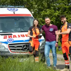 Trzech ratowników medycznych przy ambulansie. Zastanawiasz się, ile zarabia ratownik medyczny?