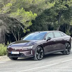 Elegancki, ciemnobrązowy Volvo ES90 na krętej drodze wśród zieleni.