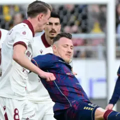 Piłkarze Pogoń Szczecin kontra Widzew Łódź. Zacięta walka o piłkę na boisku, emocje sięgają zenitu.