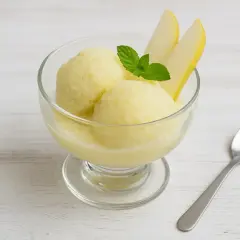 Ein Glas mit cremigem Birnen-Eis, garniert mit frischer Minze und Birnenspalten. Perfekt für einen heißen Sommertag.