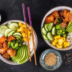 Zwei bunte Sushi Bowls mit Lachs, Avocado, Gurke, Mango und Edamame. Perfekte sushi bowl zutaten für einen gesunden Genuss.