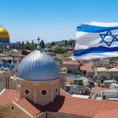 Jeruzalem z kopułą Skalnego Złota i flagą Izraela. Czy Izrael jest bezpieczny? Widok na miasto z dominującymi dachami i kopułami.